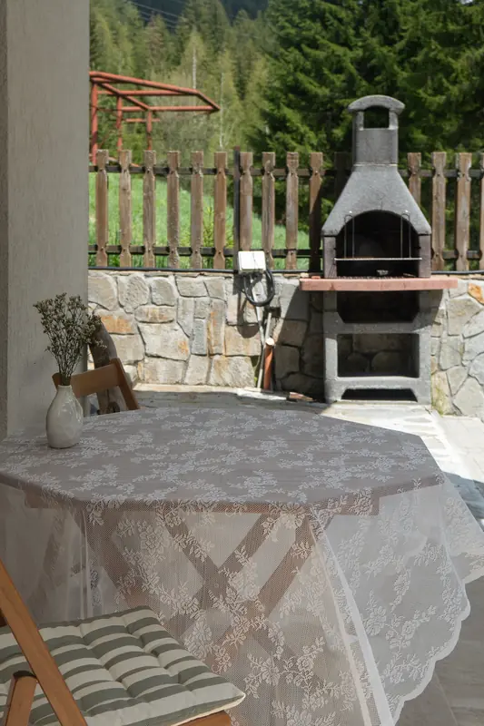 Барбекю и маса за хранене на открито под покрития двор